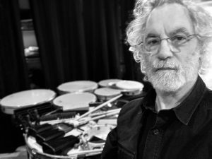 Man standing in front of drum set